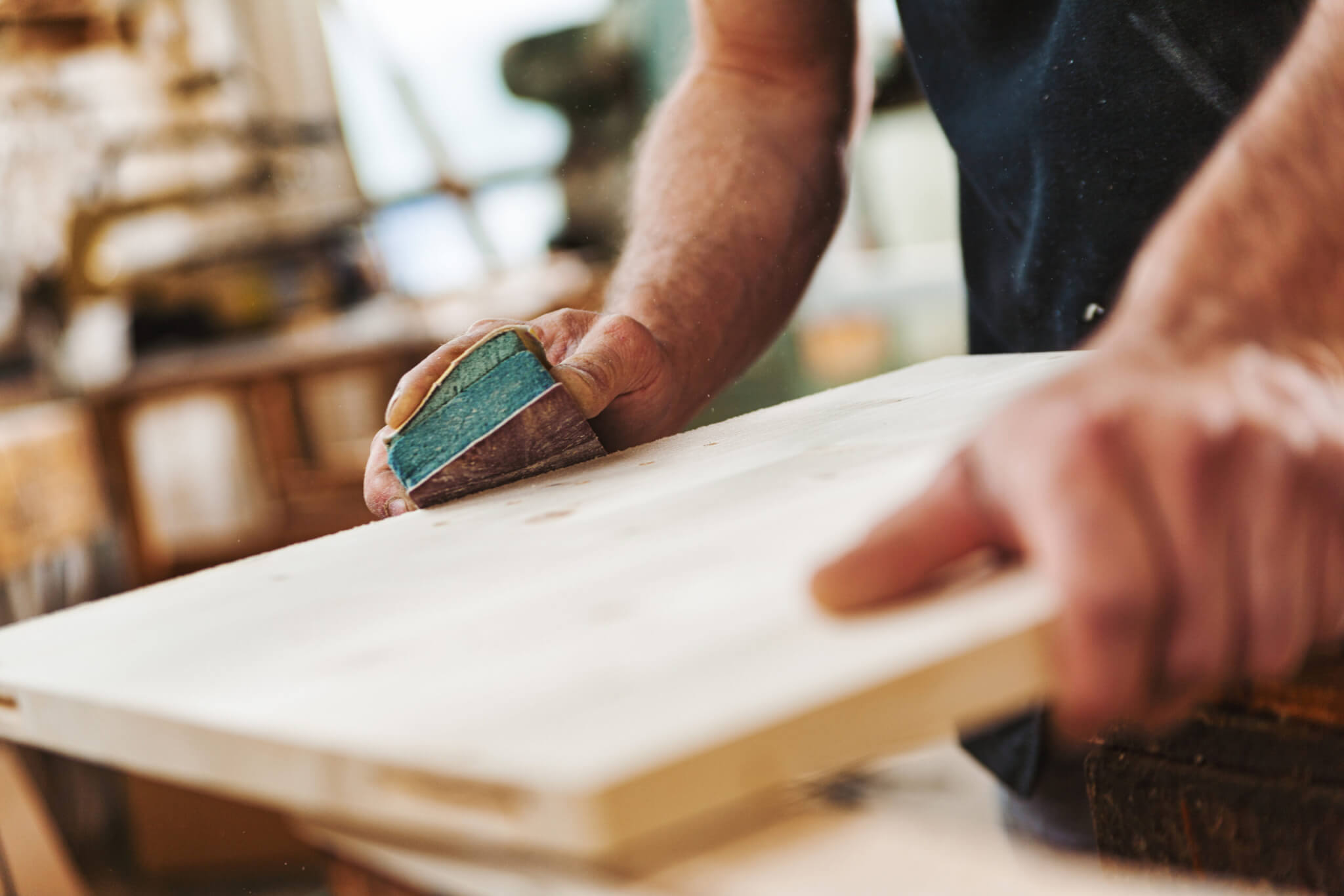 Carpenter sanding wood using sandpaper in workshop Illustration for How to Sand Cabinets the Right Way So Your Paint Job Actually Lasts